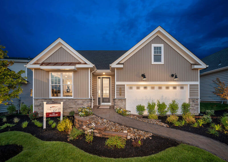 The Franklin Model With tan siding and a stone pathway going through nice landscaping